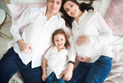 Happy pregnant woman with her husband and little daughter